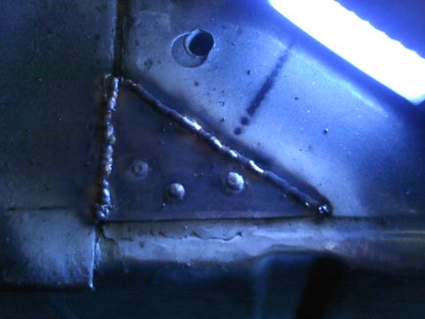 1978 Ford Bronco - This image shows a close-up view of welded metal, rivets, and a hole in what appears to be a vehicle's frame.