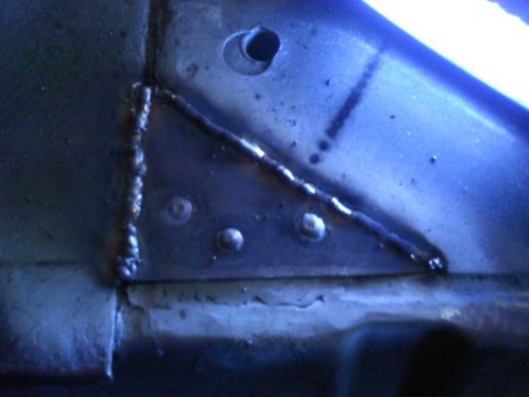 1978 Ford Bronco - Detail of a metal panel showing welding and rivets, with a hole in the upper section.