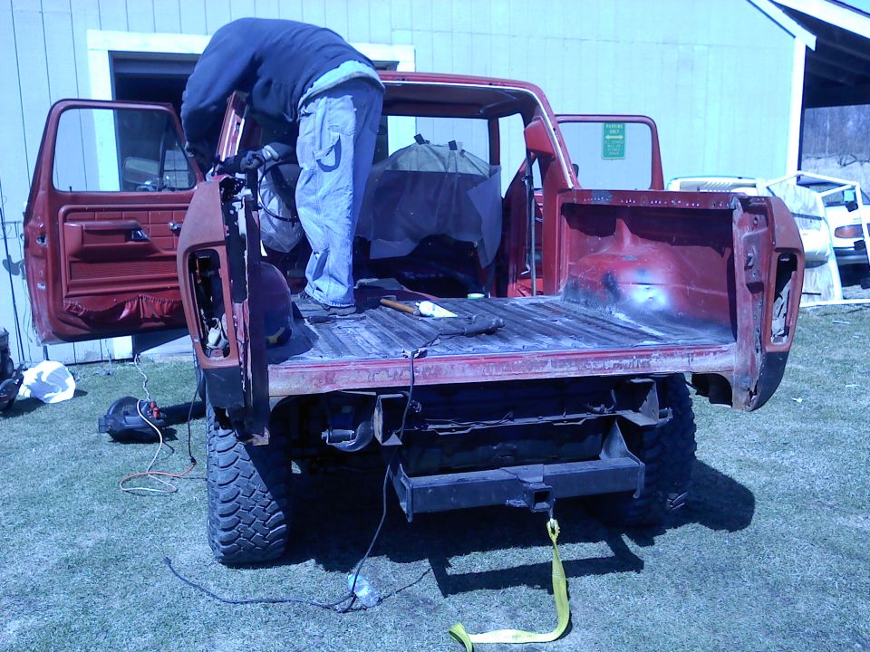 1978 Ford Bronco with bed removed, person working on rear quarter panel