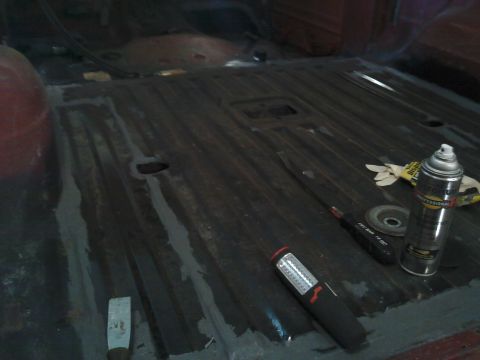 1978 Ford Bronco - Tools and a spray can are on the ribbed floor of a vehicle's interior.