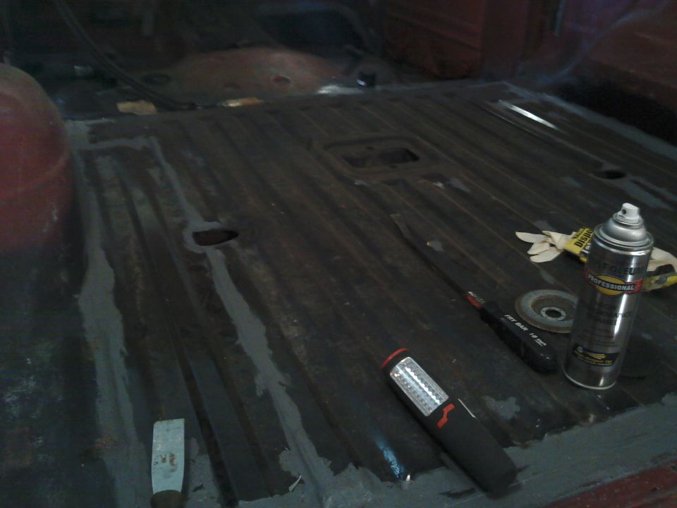 Interior floor of a vehicle with tools and a spray can on it