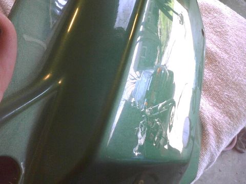 2003 Ford Crown Victoria - A reflection in a green car part shows a motorcycle and a house.