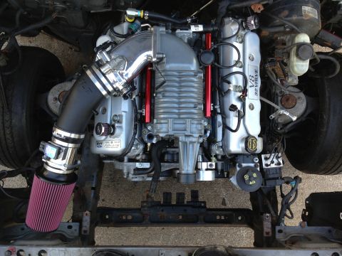 2004 Ford Crown Victoria - Engine bay view of a supercharged V8 motor with custom intake and air filter components.