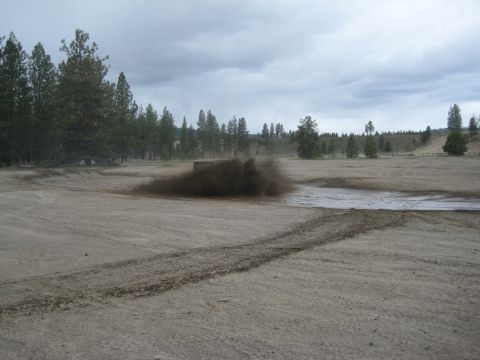 2005 Jeep Wrangler - Off-road vehicle kicking up a large amount of mud and dirt.