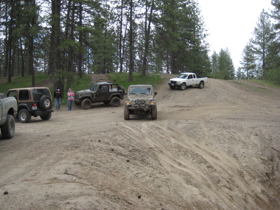 Tan Jeep Wrangler front view on dirt hill