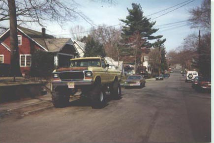 1979 Ford Bronco - This lifted 1979 Ford Bronco is parked on a suburban street with other vehicles visible.