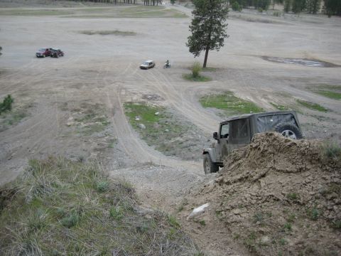 2005 Jeep Wrangler - A 2005 Jeep Wrangler navigates an off-road trail with other vehicles visible in the distance.