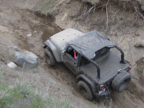 2005 Jeep Wrangler - This Jeep Wrangler is navigating a challenging off-road trail with steep inclines and loose terrain.