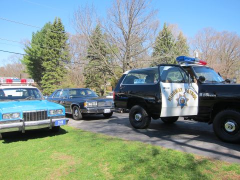 1991 Ford LTD Crown Victoria - Three police cars, including a 1991 Ford Crown Victoria LTD, are parked on a street.