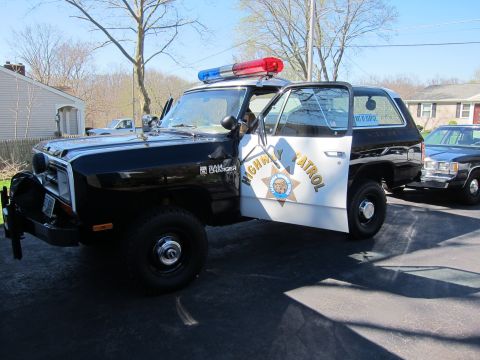 1991 Ford LTD Crown Victoria - This police SUV, marked "HIGHWAY PATROL", is parked with its door open, a light bar on the roof.
