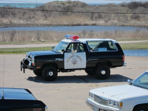 1991 Ford LTD Crown Victoria - A highway patrol SUV is parked near a body of water, with another vehicle visible in the foreground.