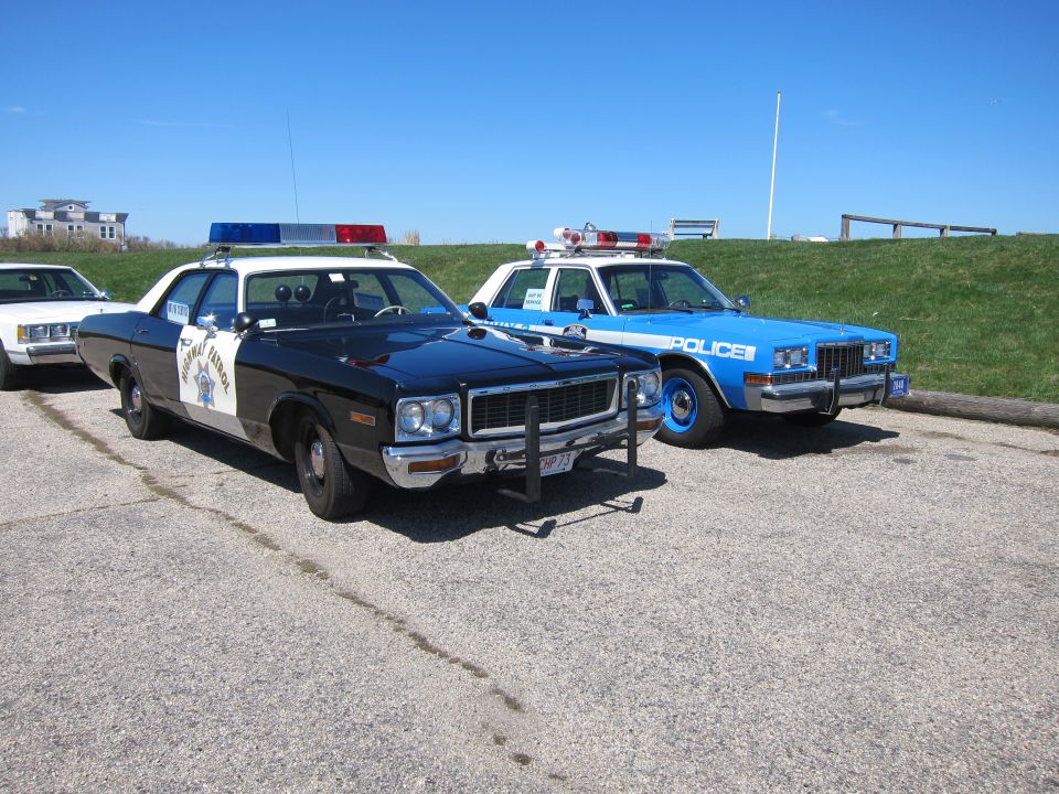 Black and blue police cars parked side-by-side on asphalt