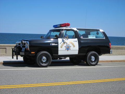 1991 Ford LTD Crown Victoria - This police SUV, marked 'HIGH PATROL', is parked on a road with the ocean in the background.