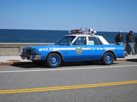 1991 Ford LTD Crown Victoria - A vintage police car, marked "HWY 3" and "2840", sits parked near the water with two onlookers.
