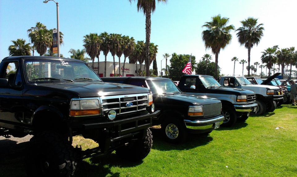 Black Ford F-250 pickup truck with lifted suspension parked in a line with other trucks