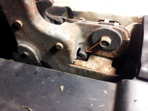 1995 Ford Bronco - A close-up view of a rusted metal bracket, showing mechanical components and an orange arrow.