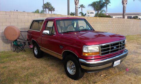 1994 Ford Bronco - This 1994 Ford Bronco is parked outdoors next to a brick wall, with a spare tire carrier attached.