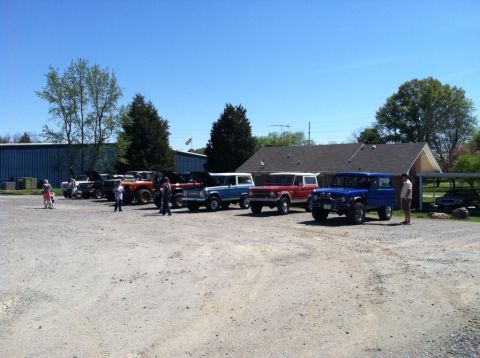 1990 Ford Bronco - A collection of Ford Broncos are gathered outdoors on a sunny day.