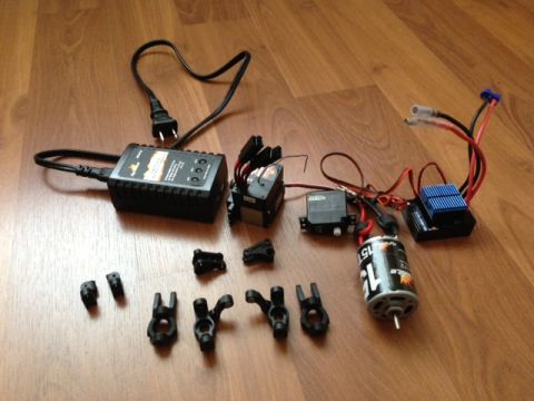 1986 Ford Bronco - RC car electronics and parts laid out on a wooden surface.