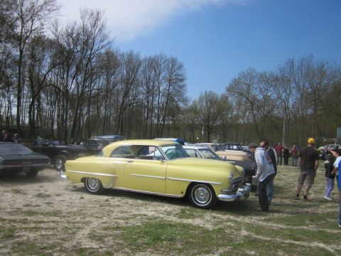 1991 Ford LTD Crown Victoria - Several vintage cars are gathered outdoors under a bright blue sky with scattered clouds.