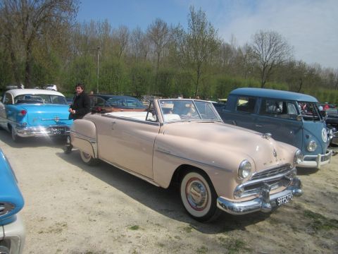 1991 Ford LTD Crown Victoria - A classic pink convertible is parked next to other vintage vehicles at an outdoor gathering.