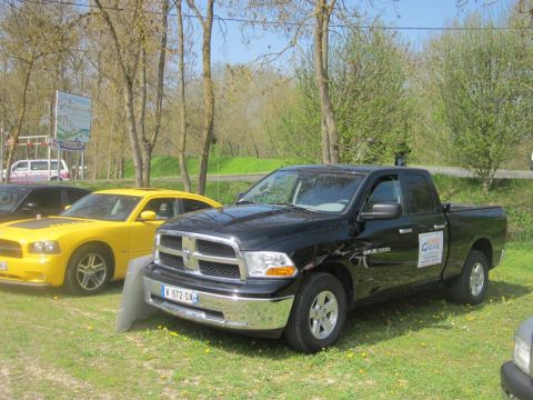 1991 Ford LTD Crown Victoria - A black Dodge Ram 1500 pickup truck is parked next to a yellow car on a grassy area.