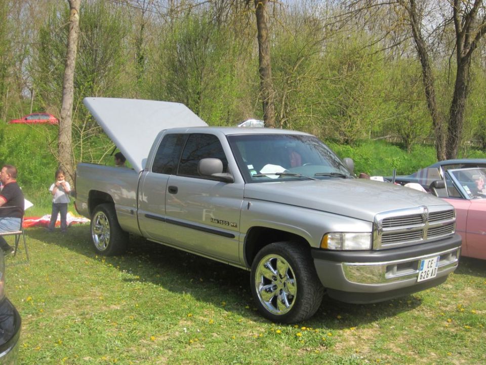 Silver Dodge Ram pickup truck, 3/4 front view, open bed cover. License plate CE 626 AD