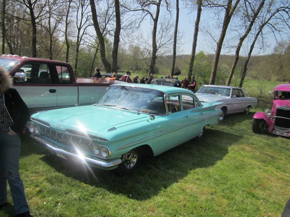 Turquoise 1959 Chevrolet Bel Air sedan, front 3/4 view, parked on grass