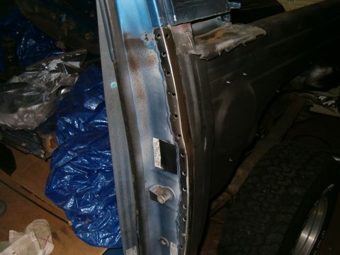 1990 Ford Bronco - Close-up of a vehicle's door frame, revealing exposed metal and signs of repair work.