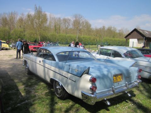 1991 Ford LTD Crown Victoria - A two-tone blue and white coupe is parked at an outdoor event with other vehicles and people in the background.
