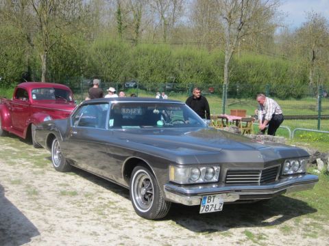 1991 Ford LTD Crown Victoria - A classic Buick Riviera is parked outdoors with a red pickup truck behind it.