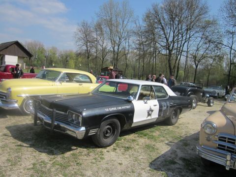 1991 Ford LTD Crown Victoria - A vintage police car is on display at an outdoor event with other classic vehicles.