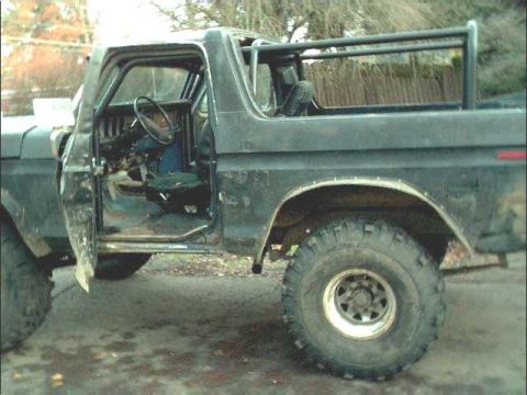 1978 Ford Bronco - Interior view of a 1978 Ford Bronco, showing the roll cage and driver's seat with the door ajar.