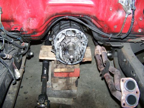 1988 Suzuki Samurai - Engine and transmission components are visible in this close-up shot, with exhaust pipes and drive shaft also in view.