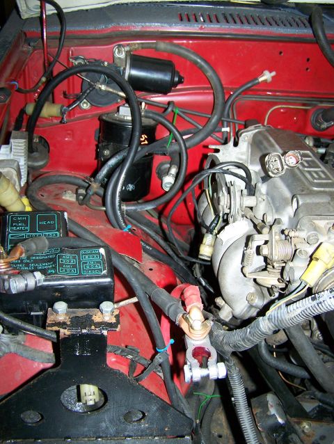 1988 Suzuki Samurai - Close-up view of the engine bay, showing various hoses, wires, and engine parts.