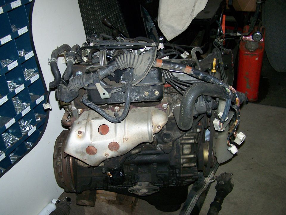Engine with exhaust manifold and wiring harness, on a stand