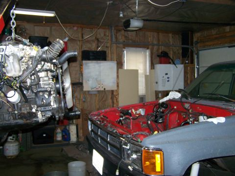 1988 Suzuki Samurai - Engine removal or installation in progress in a garage setting with another vehicle present.