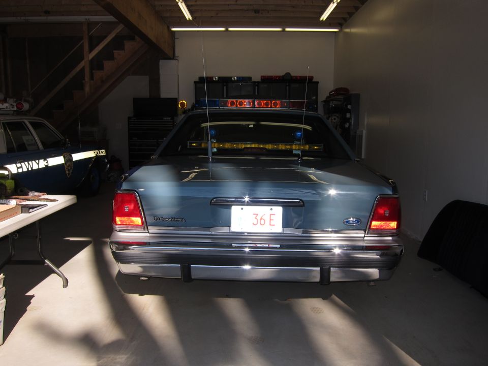 1991 Ford Crown Victoria LTD police car rear view in garage with another police car to the left