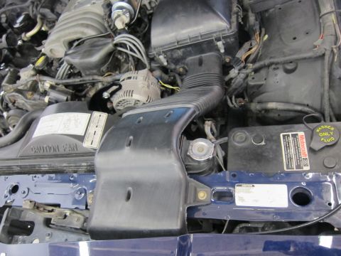 1991 Ford LTD Crown Victoria - Close-up view of a vehicle's engine bay, showing the air intake system and alternator.