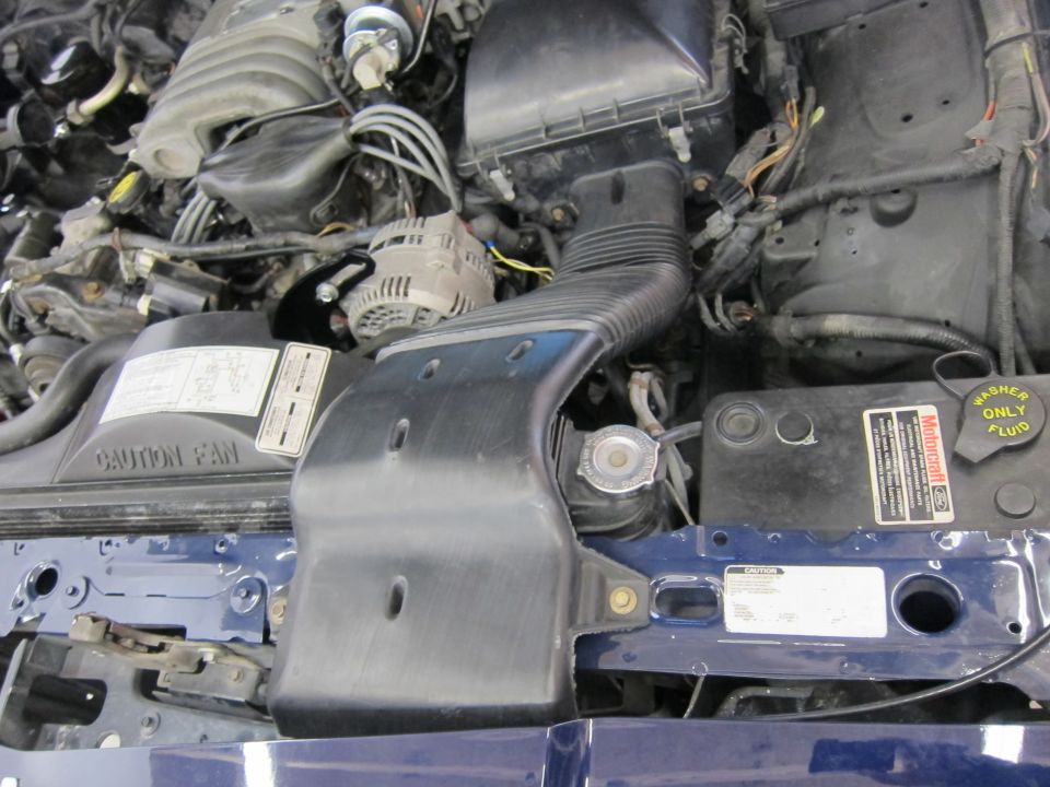 Engine bay with air intake and alternator visible