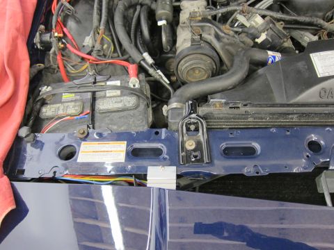1991 Ford LTD Crown Victoria - Close-up of a vehicle's engine bay, focusing on the battery and radiator components.