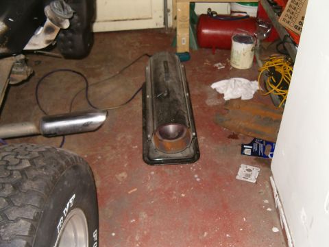 1990 Ford Bronco - Exhaust system components are visible on the floor of a garage.