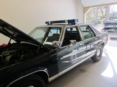 1991 Ford LTD Crown Victoria - This 1991 Ford Crown Victoria LTD police car is parked in a garage with its hood open.