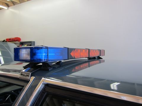 1991 Ford LTD Crown Victoria - A close-up view of a Whelen light bar mounted on the roof of a vehicle, blue and amber lights.