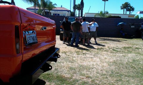 1994 Ford Bronco - Orange SUV with a custom rear bumper and a California license plate is parked outdoors.