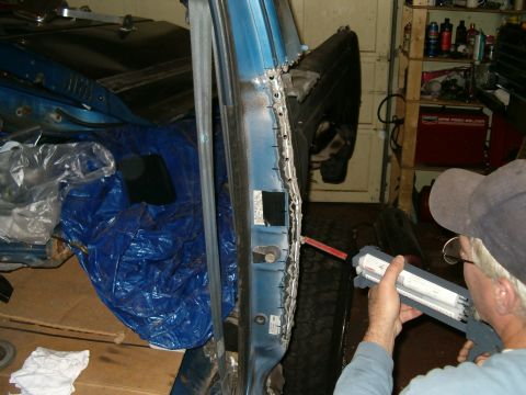 1990 Ford Bronco - Repairing rust damage on a car door, exposing the metal for treatment.