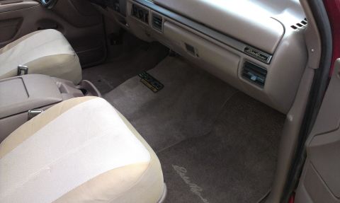 1994 Ford Bronco - The interior of a 1994 Ford Bronco features two-tone seats, a tan dashboard, and 'Eddie Bauer' badging on the floor mats.