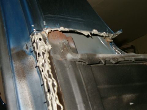 1990 Ford Bronco - This photo shows a section of a vehicle's body undergoing repair, with visible rust and sealant application.