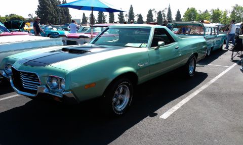 1994 Ford Bronco - This 1972 Ford Ranchero is parked in a lot with other vehicles under a blue umbrella.