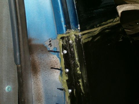 1990 Ford Bronco - Close-up of a body panel seam showing sealant application and rivets, indicative of repair or assembly work.